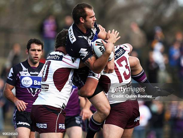 Scott Anderson of the Storm is tackled during the round 24 NRL match between the Melbourne Storm and the Manly Warringah Sea Eagles at Olympic Park...