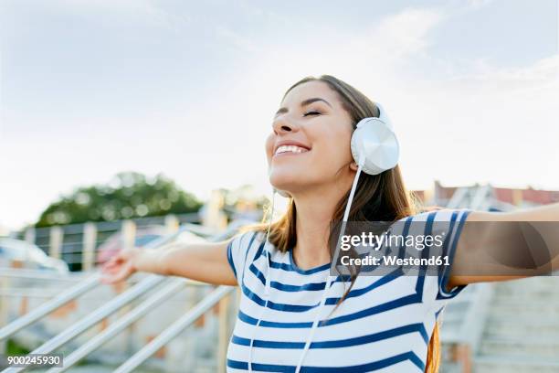 happy young woman wearin headphones enjoying the summer - striped shirt stock pictures, royalty-free photos & images