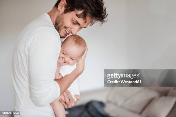 father holding baby girl at home - baby stock-fotos und bilder