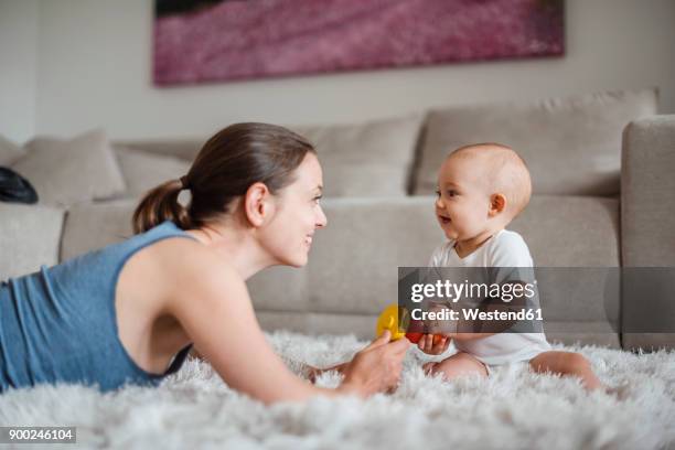 happy baby girl with mother playing on carpet at home - baby happy cute smiling baby only stockfoto's en -beelden