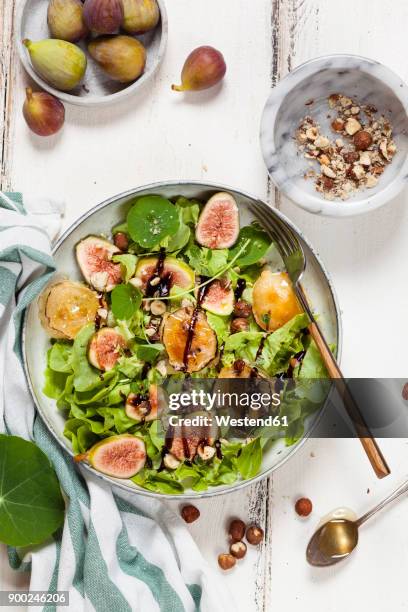 platter of green salad with figs, crema di balsamico, honey hazelnuts and baked goat cheese - nasturtium fotografías e imágenes de stock