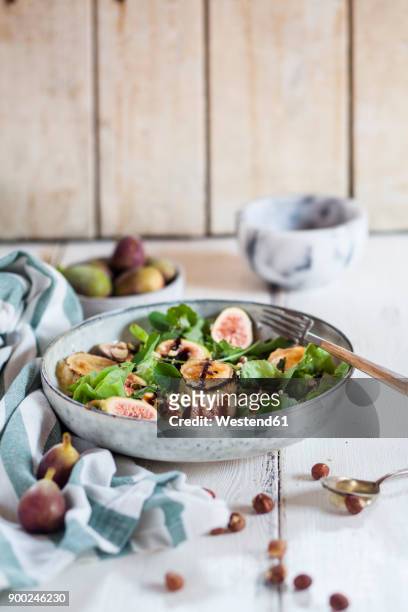 platter of green salad with figs, crema di balsamico, honey hazelnuts and baked goat cheese - nasturtium fotografías e imágenes de stock