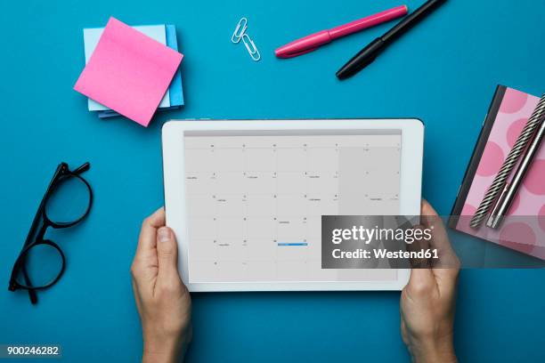 top view of woman holding tablet with calendar on desk - online calendar stock pictures, royalty-free photos & images