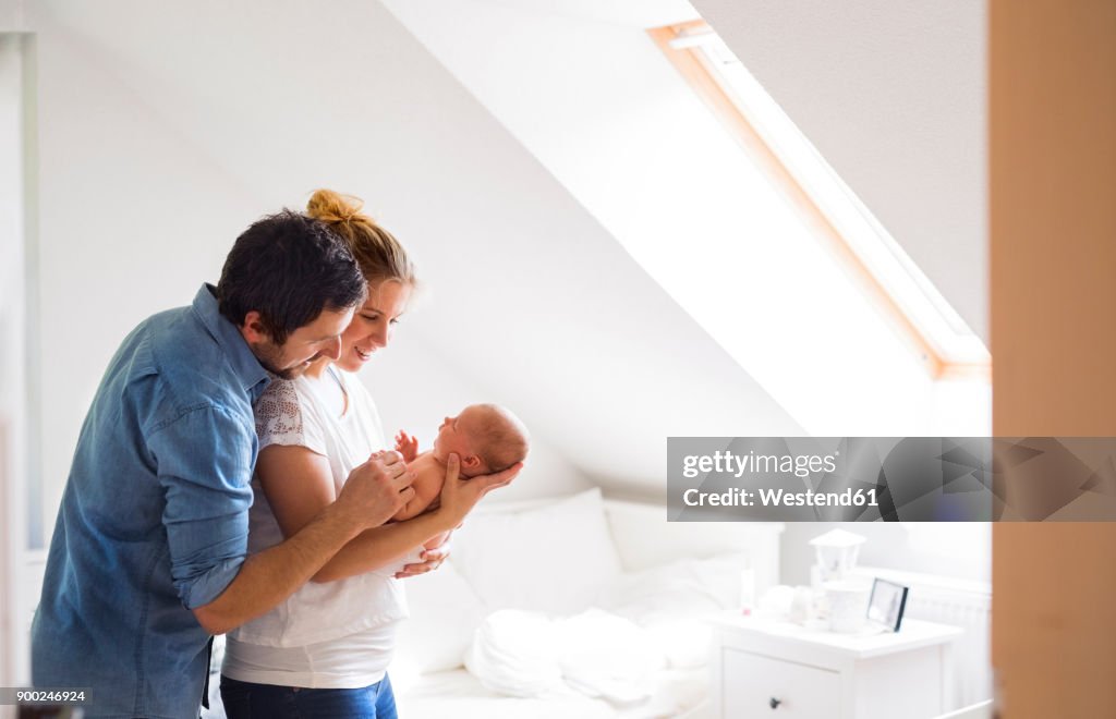 Parents cuddling with little baby at home
