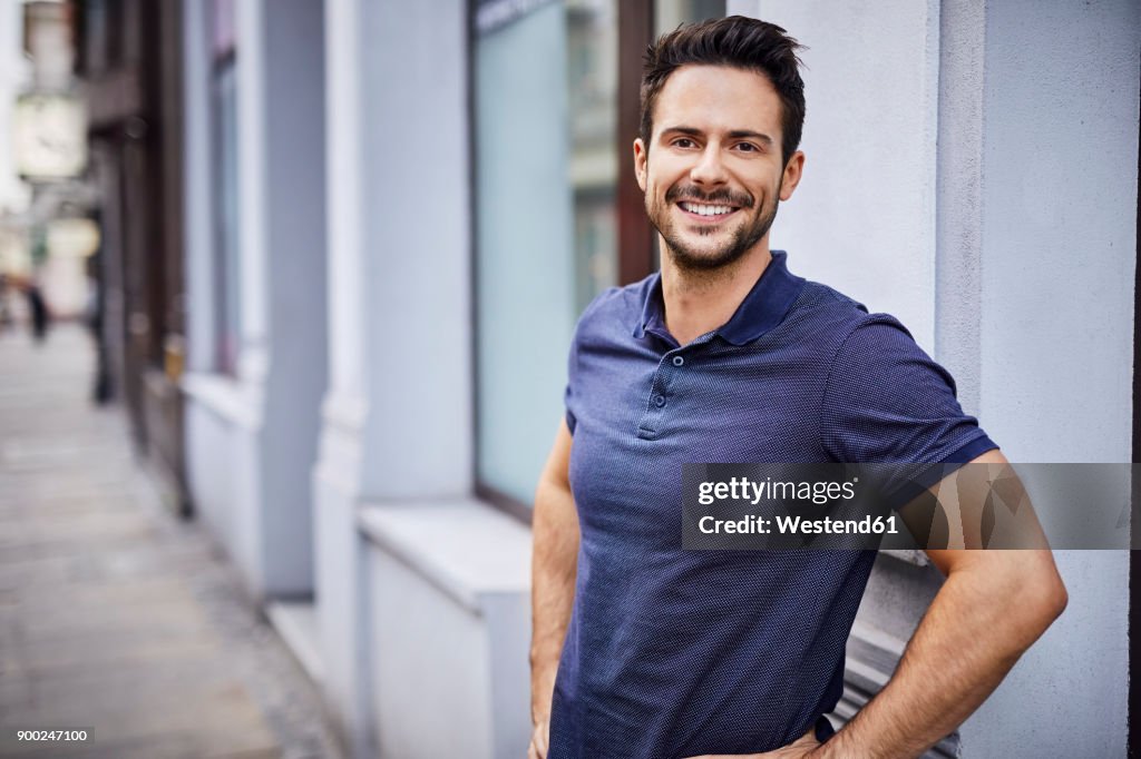 Smiling man standing on city street