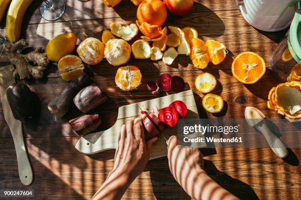 woman's hands chopping beetroot for squeezing juice - saftpresse stock-fotos und bilder