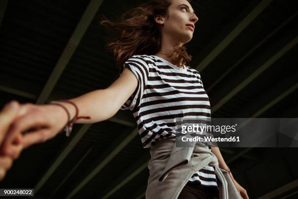 young woman balancing under a bridge - hände paar stock-fotos und bilder