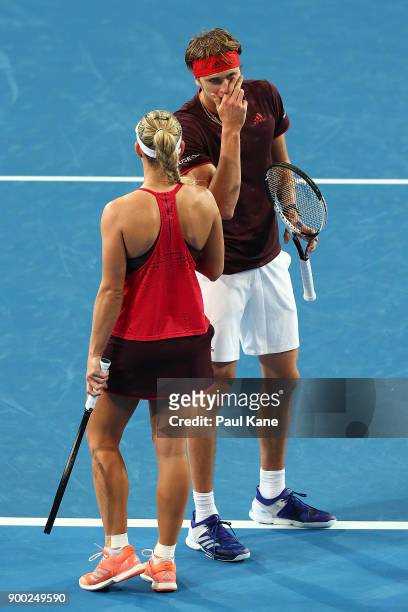 Alexander Zverev and Angelique Kerber of Germany talk tactics during the mixed doubles match against Elise Mertens and David Goffin of Belgium on day...