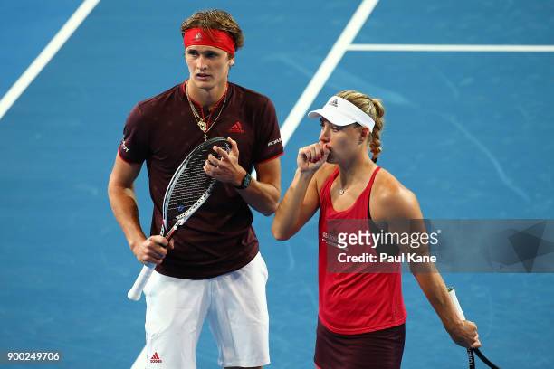Alexander Zverev and Angelique Kerber of Germany talk tactics during the mixed doubles match against Elise Mertens and David Goffin of Belgium on day...