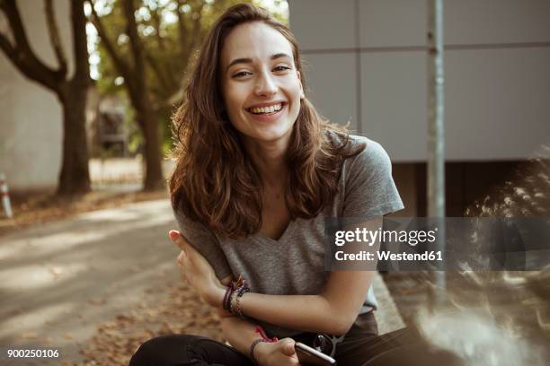 portrait of happy young woman outdoors - mujeres jóvenes fotografías e imágenes de stock