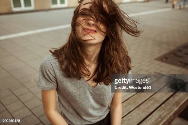 young woman outdoors with windswept hair - haare stock-fotos und bilder