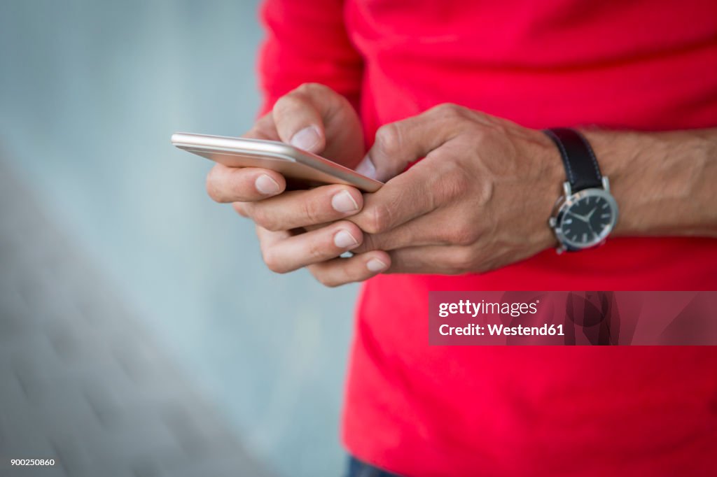 Hands of man writing text message on a smartphone