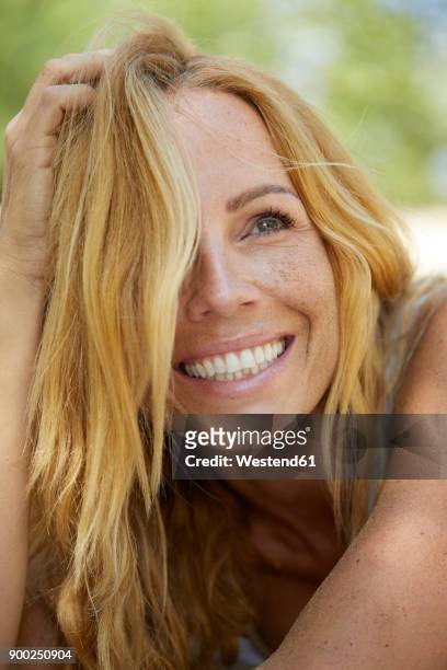 portrait of happy strawberry blonde woman with freckles - frau beauty haare anfassen stock-fotos und bilder