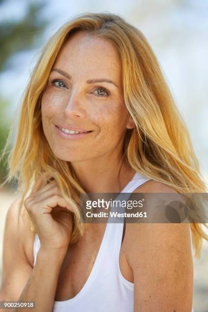 portrait of smiling strawberry blonde woman with freckles - attractive older woman stock-fotos und bilder