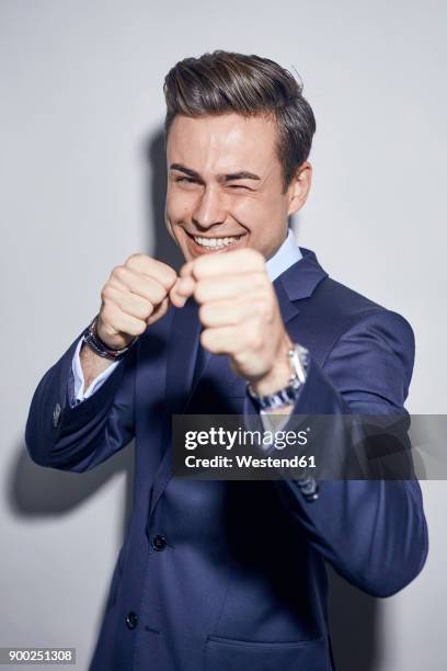 portrait of laughing young businessman boxing - vechtsport stockfoto's en -beelden