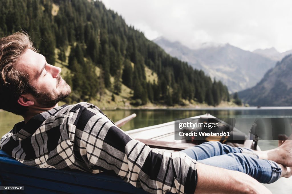 Austria, Tyrol, Alps, relaxed man in boat on mountain lake