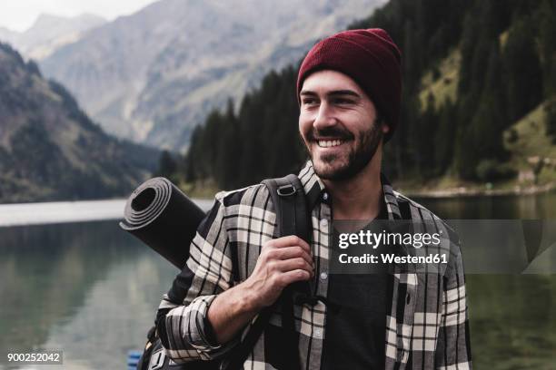 austria, tyrol, alps, portrait of smiling man at mountain lake - man backpack stock pictures, royalty-free photos & images