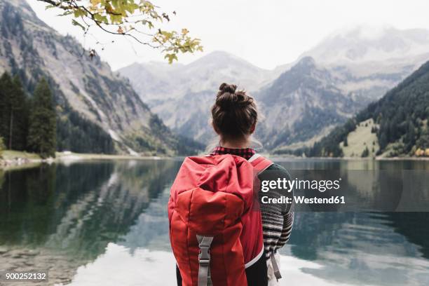 austria, tyrol, alps, hiker standing at mountain lake - 背包客 個照片及圖片檔