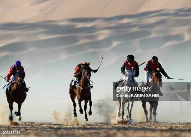 Jockeys compete in a race for purebred Arab horses during the Liwa 2018 Moreeb Dune Festival on January 1 in the Liwa desert, some 250 kilometres...