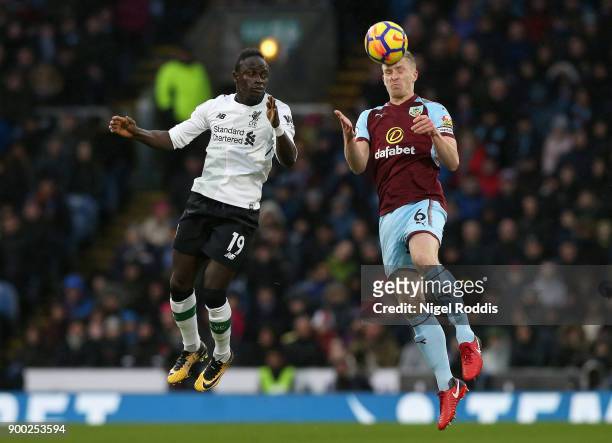 Ben Mee of Burnley wins a header over Sadio Mane of Liverpool during the Premier League match between Burnley and Liverpool at Turf Moor on January...
