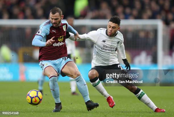 Steven Defour of Burnley is challenged by Alex Oxlade-Chamberlain of Liverpool during the Premier League match between Burnley and Liverpool at Turf...