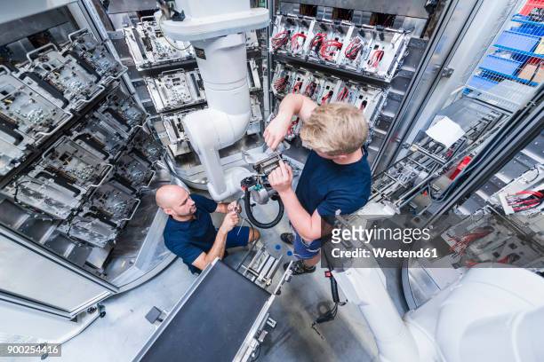 two colleagues working at industrial robot in modern factory - wide angle imagens e fotografias de stock