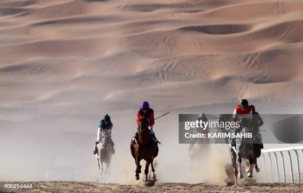 Jockeys compete in a race for purebred Arab horses during the Liwa 2018 Moreeb Dune Festival on January 1 in the Liwa desert, some 250 kilometres...