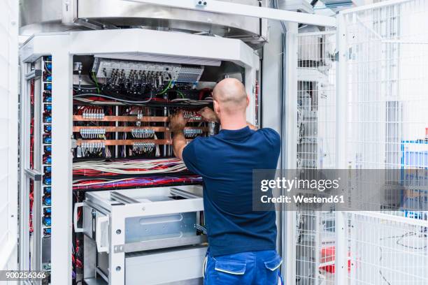 man using voltmeter in modern factory - voltmeter stock pictures, royalty-free photos & images