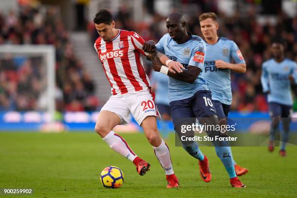 Geoff Cameron of Stoke City and Mohamed Diame of Newcastle United battle for possession during the Premier League match between Stoke City and...