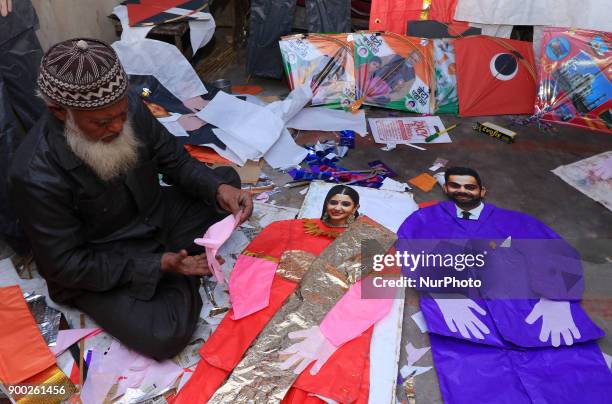 An Indian Kitemaker Abdul Gaffur gives a final touch to his kites made from the cut out of Bollywood actress Anushka Sharma and Indian cricketer...