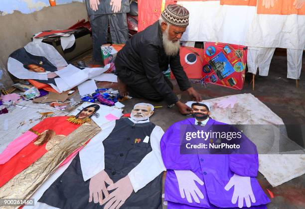 An Indian Kitemaker Abdul Gaffur gives a final touch to his kites made from the cut out of Bollywood actress Anushka Sharma , Indian cricketer Virat...