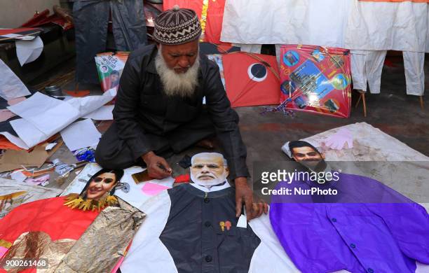 An Indian Kitemaker Abdul Gaffur gives a final touch to his kites made from the cut out of Bollywood actress Anushka Sharma , Indian cricketer Virat...