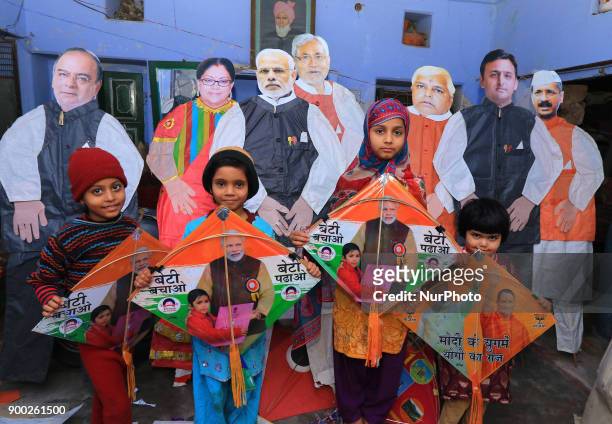 Indian girls pose with kites message on its ' Save Girls Child' ahead of Hindu festival Makar Sakranti at Handipura of Ramganj Bazar in Jaipur,...