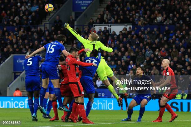Huddersfield Town's Danish goalkeeper Jonas Lossl punches the ball clear during the English Premier League football match between Leicester City and...