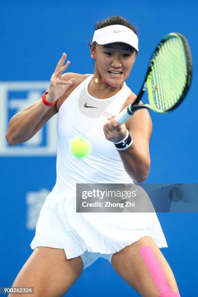 Xiyu Wang of China returns a shot during the match against Timea Babos of Hungary during Day 2 of 2018 WTA Shenzhen Open at Longgang International...
