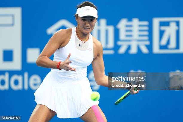 Xiyu Wang of China returns a shot during the match against Timea Babos of Hungary during Day 2 of 2018 WTA Shenzhen Open at Longgang International...