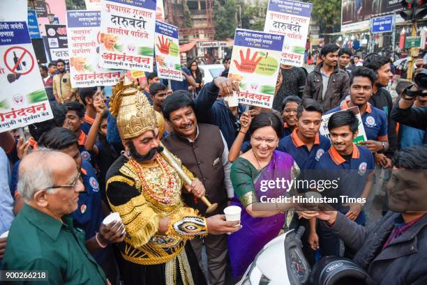 Mayor Mukta Tilak and a man dressed as Yamraj and students of MMCC college offering milk to commuters on New Years eve at Goodluck chowk, on December...