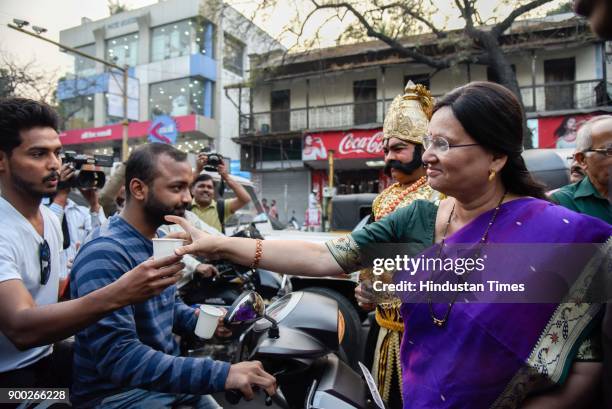 Mayor Mukta Tilak and a man dressed as Yamraj and students of MMCC college offering milk to commuters on New Years eve at Goodluck chowk, on December...