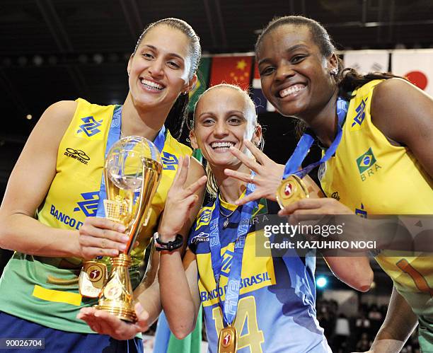 Brazilian volleyball team captain Danielle Lins and team-mates Fabiana de Oliveira and Fabiana Claudino celebrate their victory during an award...