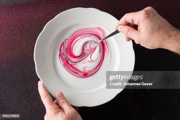 block printing, hand mixing red pigment color and white binder with spoon on plate, on felt mat, bad aussee, styria, austria - bad aussee stock pictures, royalty-free photos & images