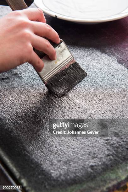 block printing, hand with brush spreading paint on felt mat, bad aussee, styria, austria - hand block print stock pictures, royalty-free photos & images