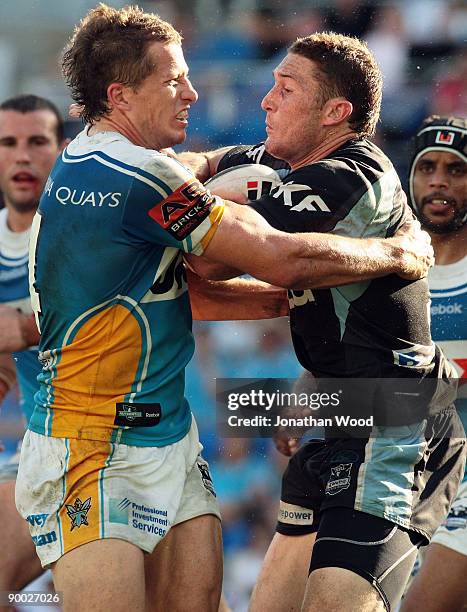 Ben Pomeroy of the Sharks is tackled byJordan Atkins of the Titans during the round 24 NRL match between the Gold Coast Titans and the Cronulla...