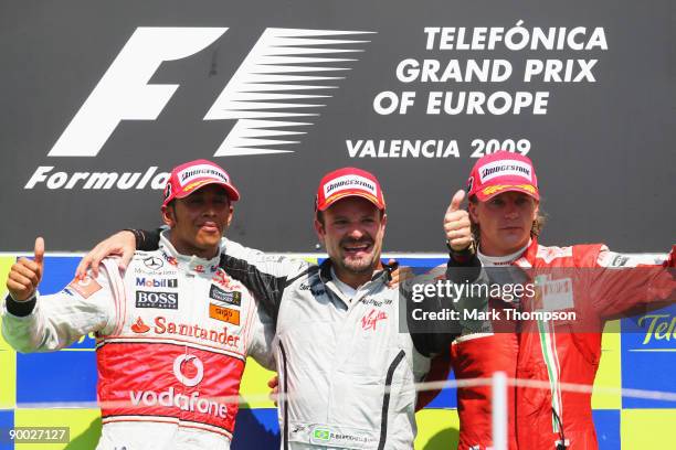 Race winner Rubens Barrichello of Brazil and Brawn GP celebrates on the podium with second placed Lewis Hamilton of Great Britain and McLaren...