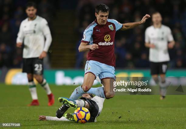 Adam Lallana of Liverpool tackles Jack Cork of Burnley during the Premier League match between Burnley and Liverpool at Turf Moor on January 1, 2018...