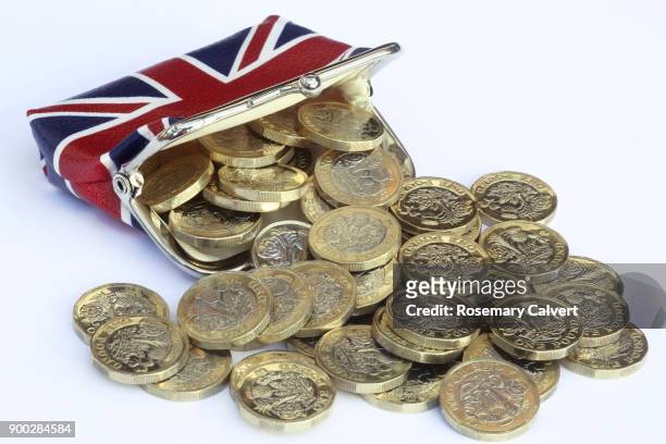 union jack purse with one pound coins spilling out. - pièce de monnaie britannique photos et images de collection