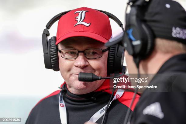 Louisville Cardinals head coach Bobby Petrino talks with an assistant during the game between the Louisville Cardinals and the Mississippi State...