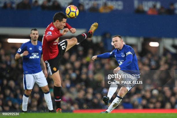 Everton's English striker Wayne Rooney shot is blocked by Manchester United's Spanish midfielder Ander Herrera during the English Premier League...
