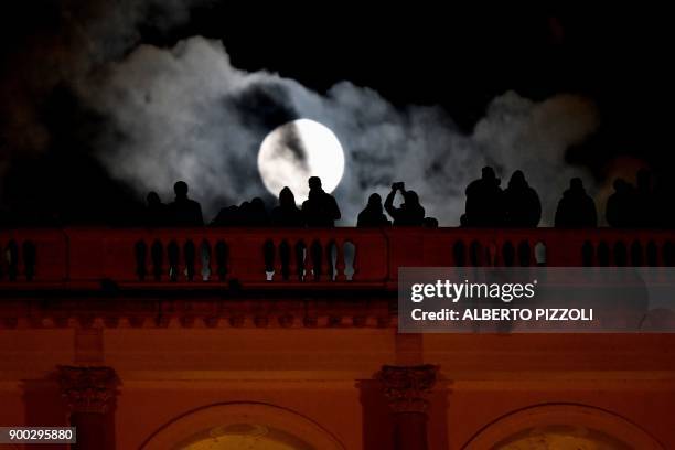 People admires the "super moon" from the Terrazza del Pincio, in Rome, on January 1, 2018. Supermoons happen when a full moon approximately coincides...