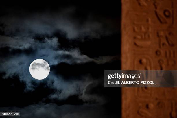 Picture taken on January 1, 2018 shows the "super moon" rising over Piazza del Popolo, in Rome. Supermoons happen when a full moon approximately...