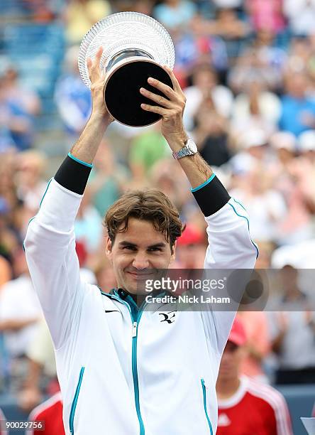 Roger Federer of Switzerland holds the winners trophy aloft after defeating Novak Djokovic of Serbia in the Singles Final during day seven of the...